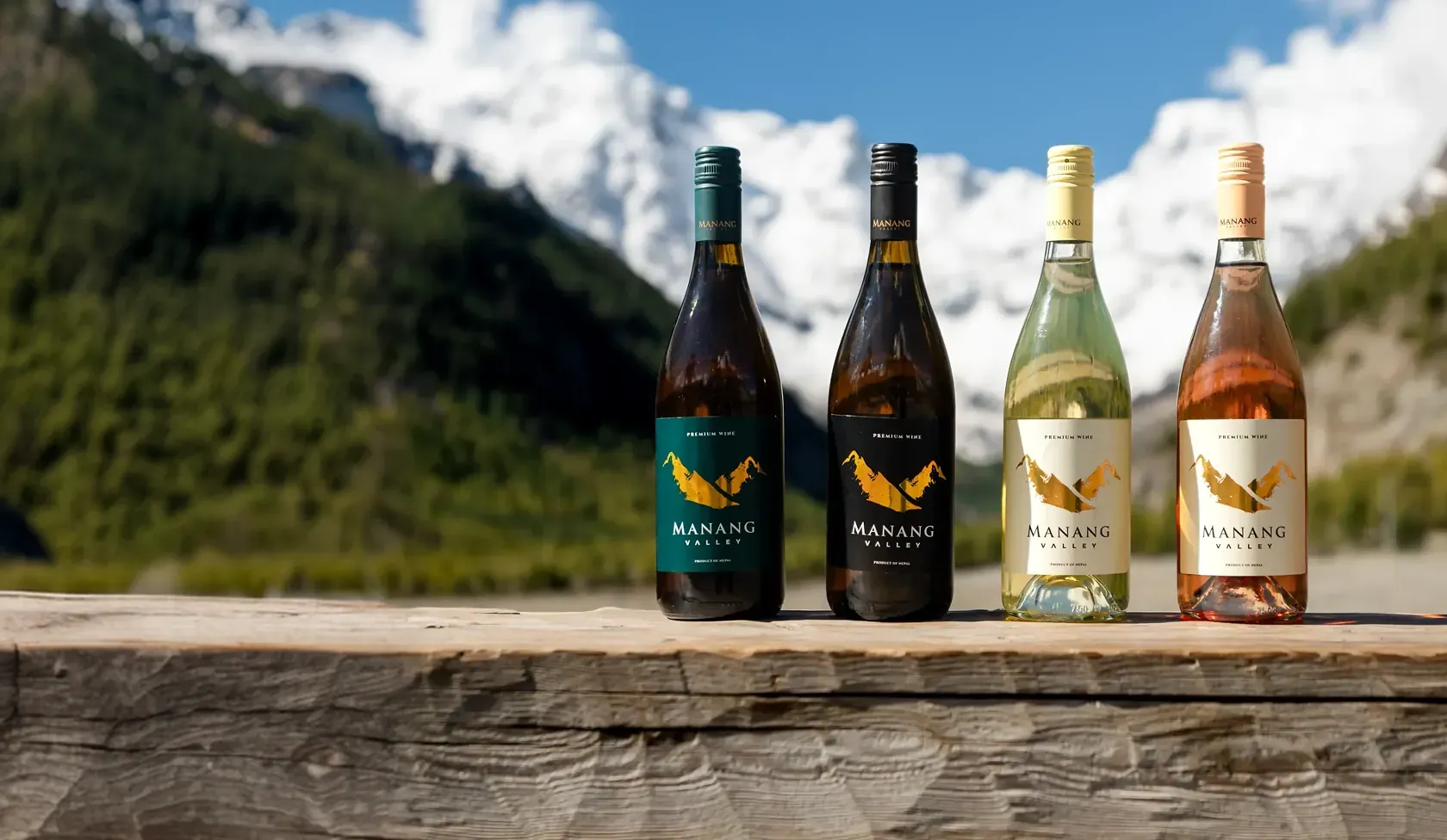 The four Manang Valley wines on a wooden table with snow-capped Himalayan peaks behind