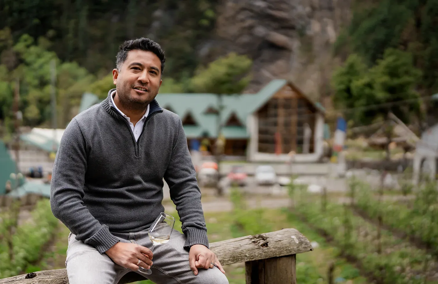Ashraya Ranjitkar seated at the winery in Manang, holding a glass of apple wine