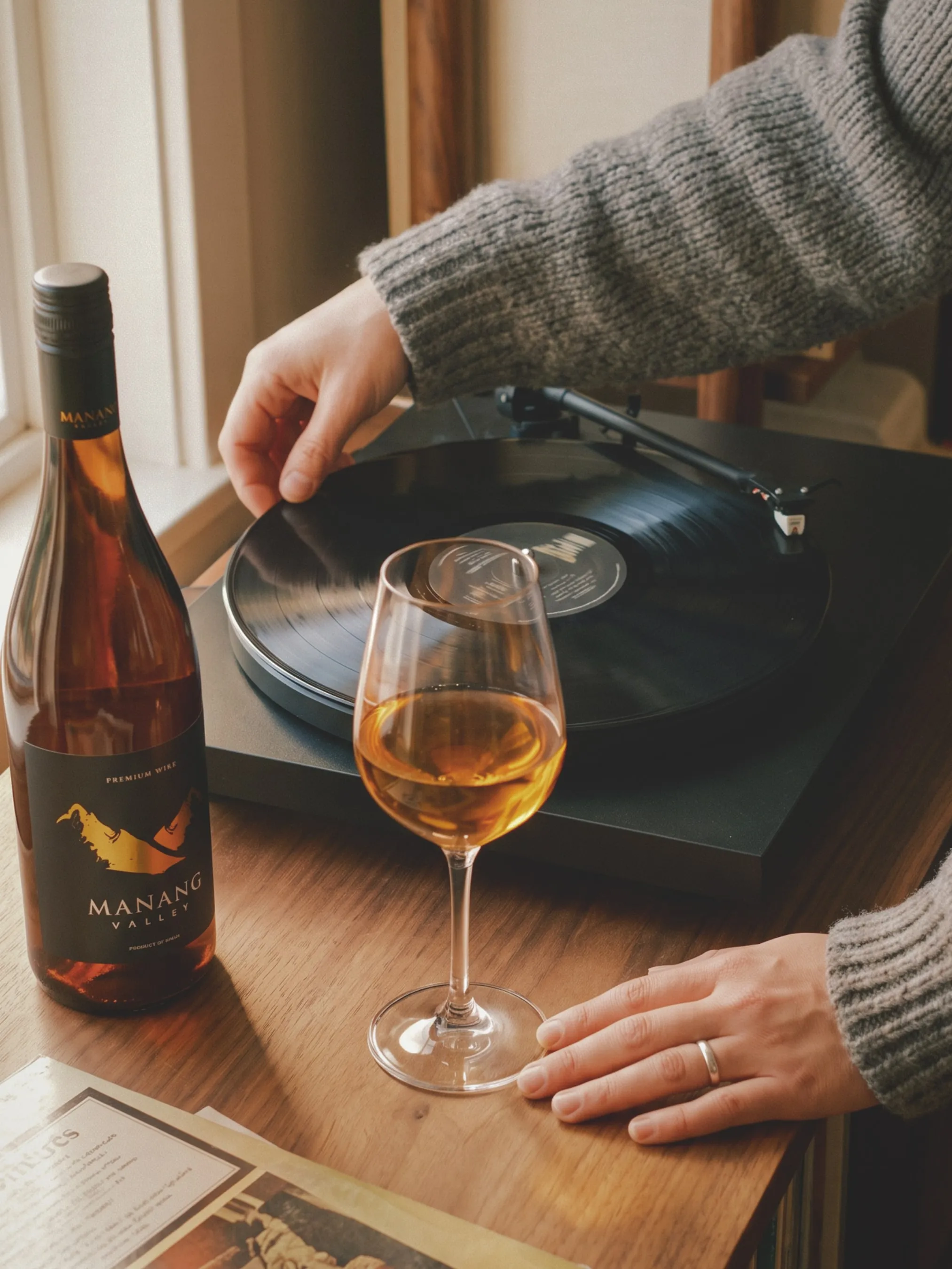 A glass of Manang Valley wine beside a record player